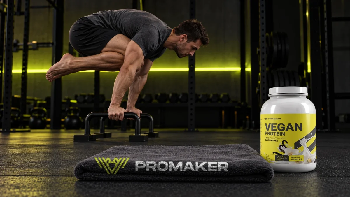 Mężczyzna w tuck planche na poręczach w siłowni, obok odżywka Vegan Protein PROMAKER i ręcznik z logo