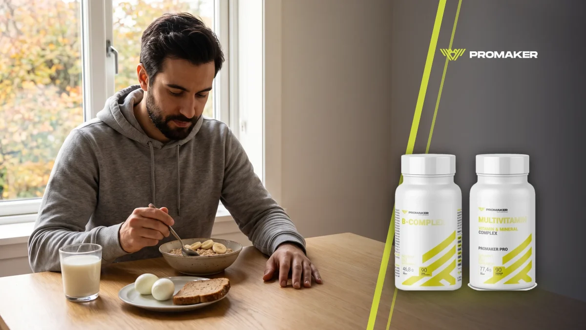 Mężczyzna w szarej bluzie je przy stole owsiankę z bananem, obok jajka na twardo, chleb pełnoziarnisty i mleko; z prawej B-Complex i Multivitamin Complex Promaker