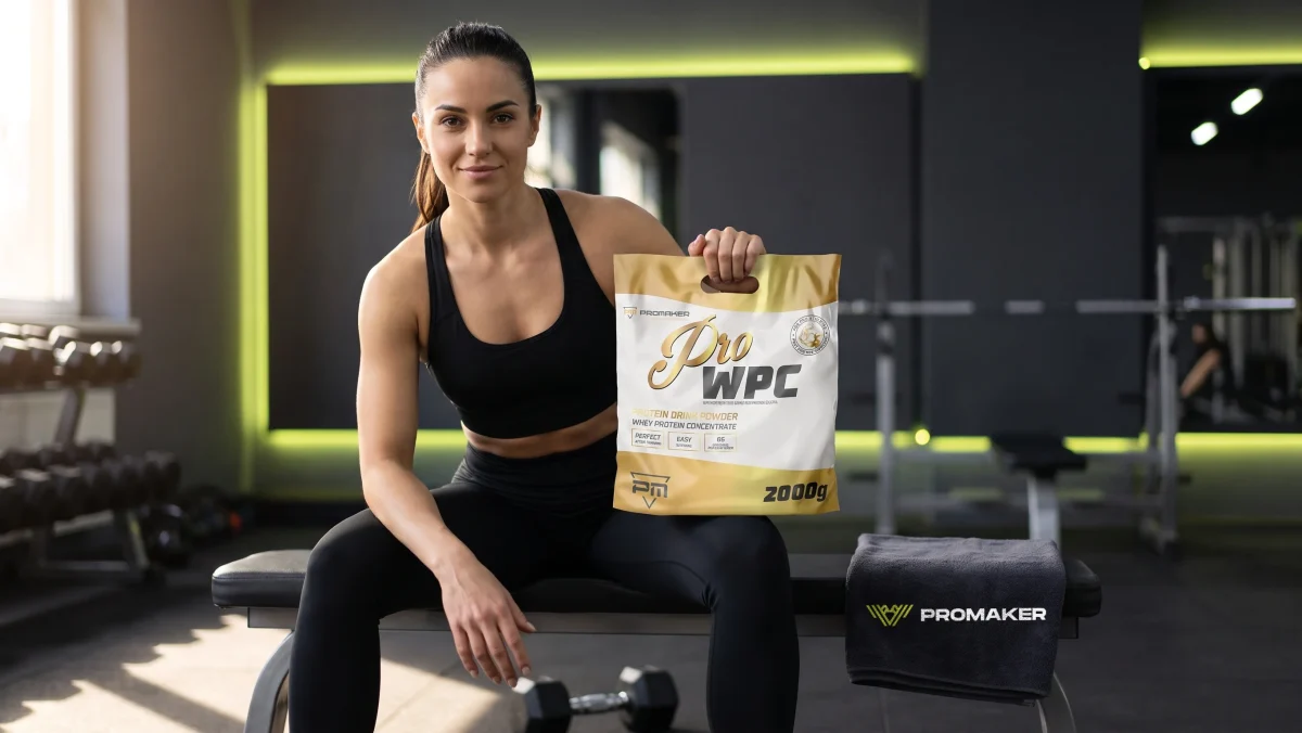 Kobieta na ławce w siłowni trzyma odżywkę białkową PROMAKER Pro WPC 2000 g, obok ręcznik PROMAKER